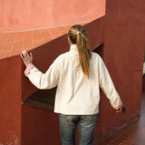 Back view of the cream corduroy jacket worn with jeans, showing the relaxed fit and length