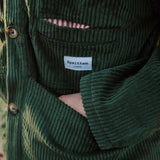 Close-up of the green corduroy jacket's front pocket and Speltham label, with the striped lining peeking out